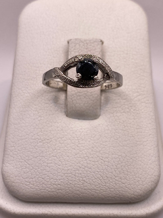 Anillo solitario de plata con circonia negra brillante, frente frontal sobre fondo blanco