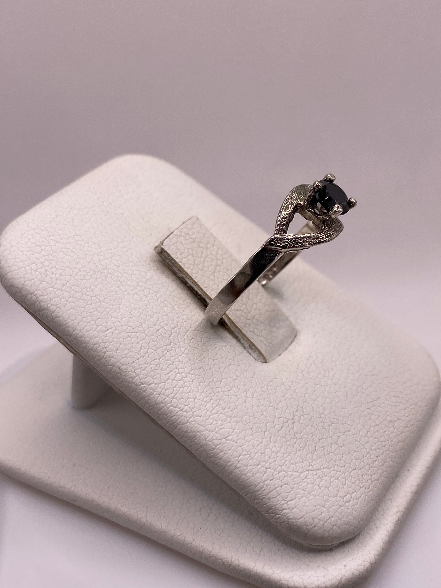 Anillo solitario de plata .925 en mano de mujer, mostrando brillo y elegancia
