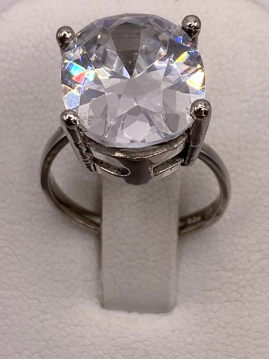 Anillo solitario de plata con circonia ovalada brillante en la mano de una mujer