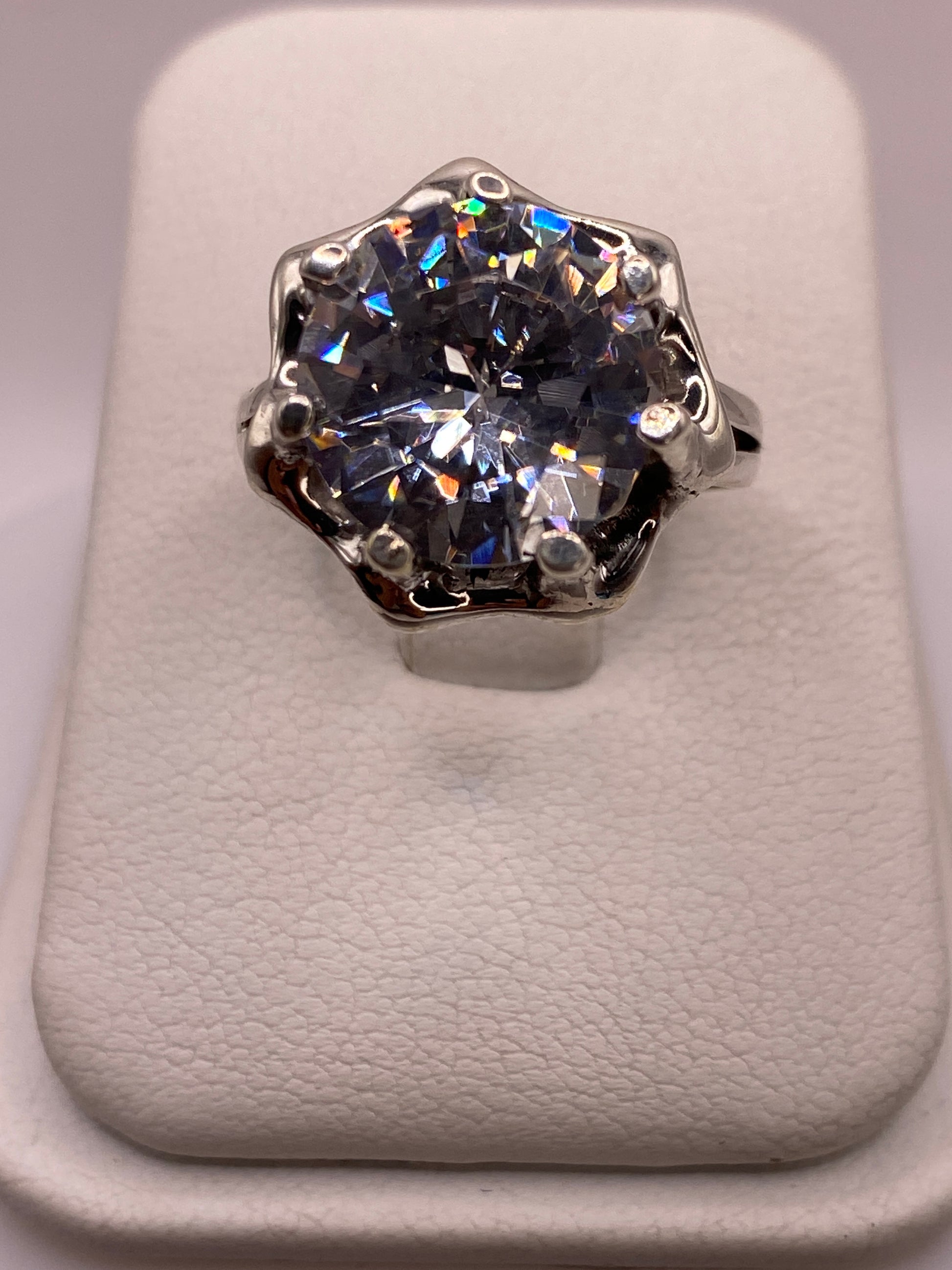 Anillo solitario de plata .925 con circonia blanca en frente, mostrando el brillo tipo diamante en luz natural