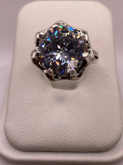 Anillo solitario de plata .925 con circonia blanca en frente, mostrando el brillo tipo diamante en luz natural