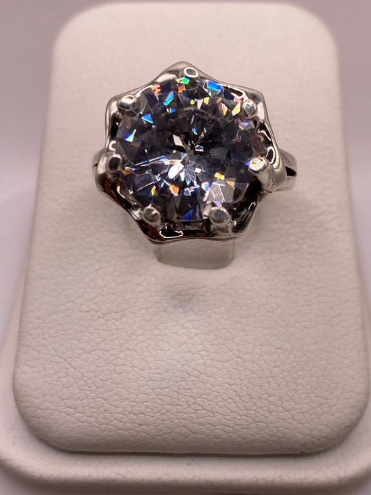 Anillo solitario de plata .925 con circonia blanca en frente, mostrando el brillo tipo diamante en luz natural