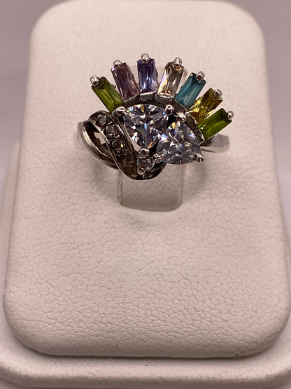 Anillo de plata .925 con cluster de siete circonias multicolor en tonos azul, púrpura, verde y amarillo