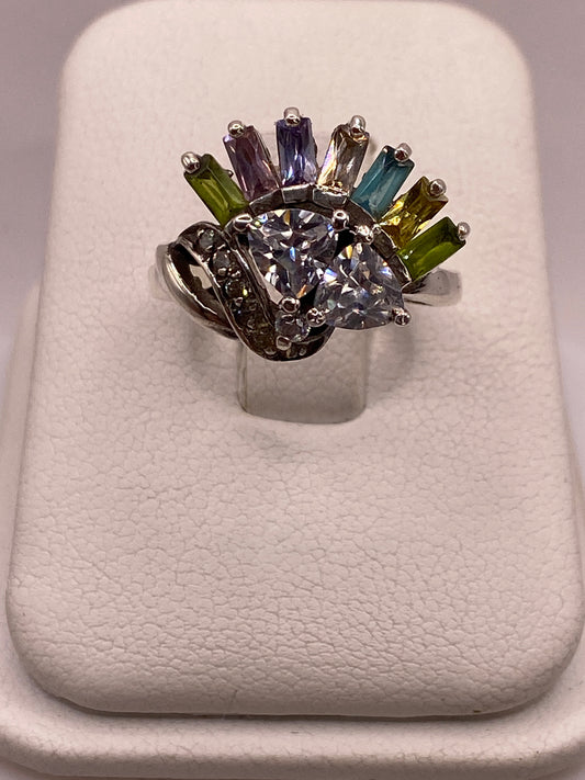 Anillo de plata .925 con cluster de siete circonias multicolor en tonos azul, púrpura, verde y amarillo