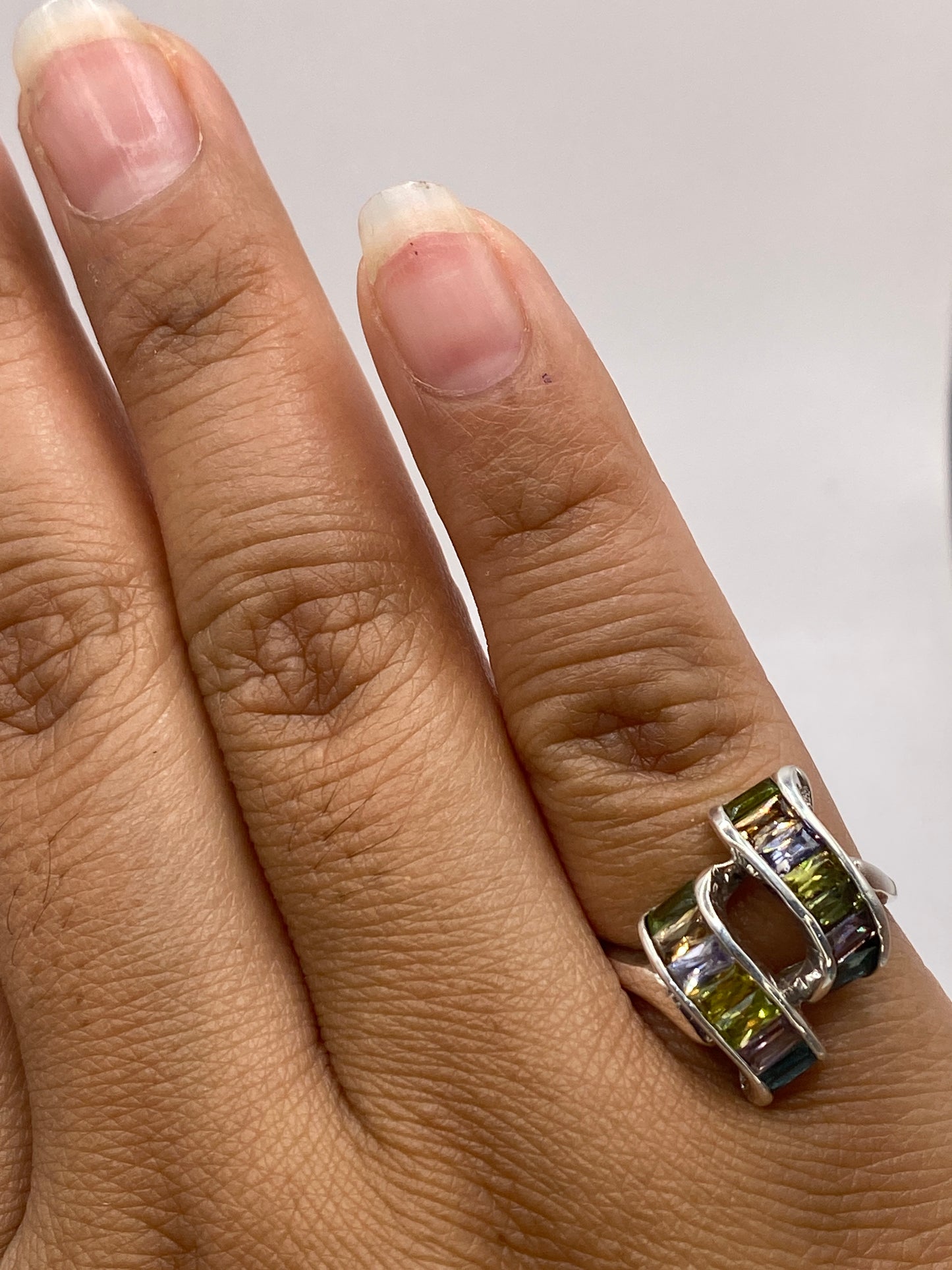 Anillo de plata multicolor sobre la balanza de precisión mostrando peso de 4.3 gramos