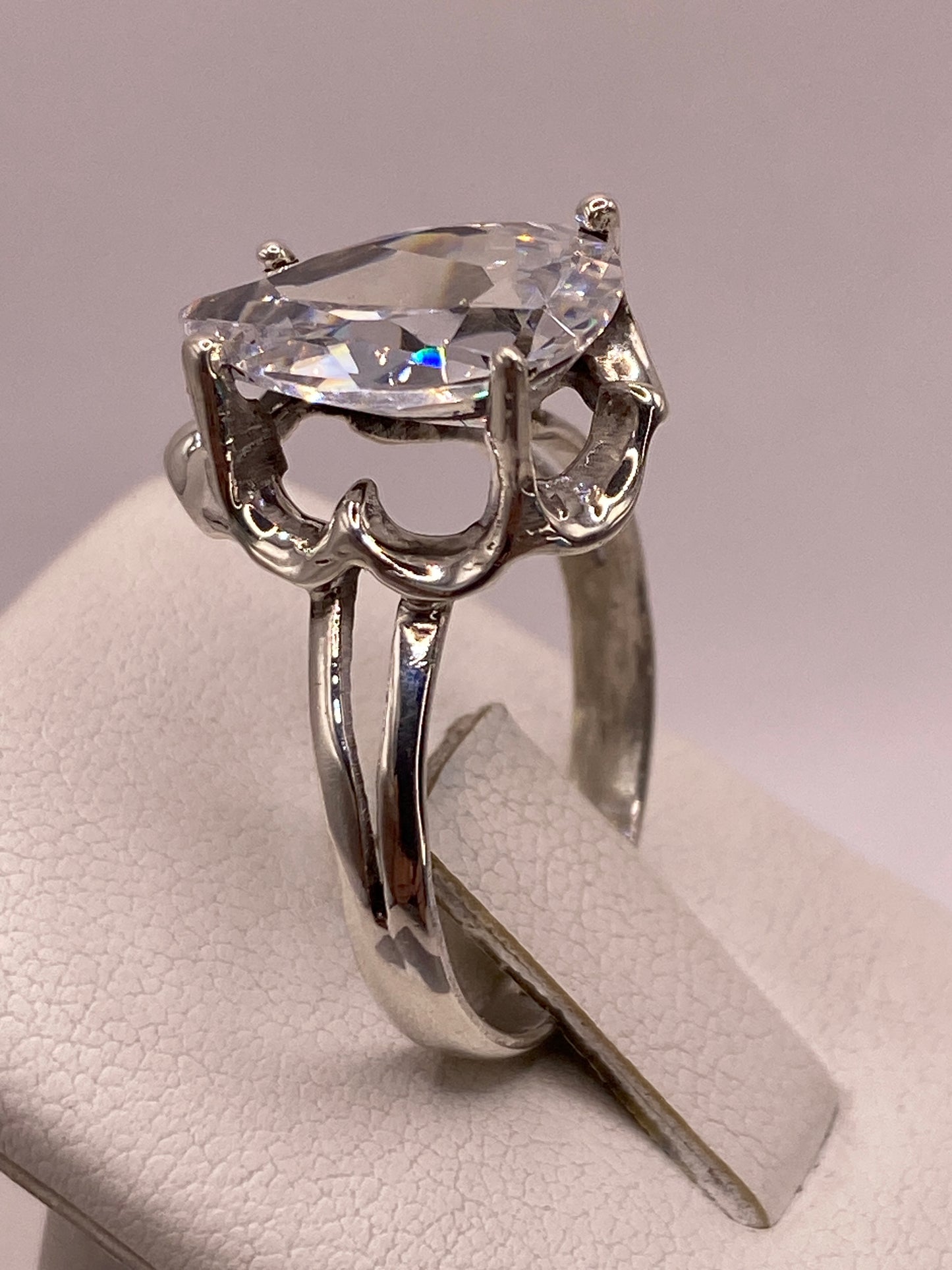 Anillo solitario gota en mano de mujer, brillo transparente de la circonia