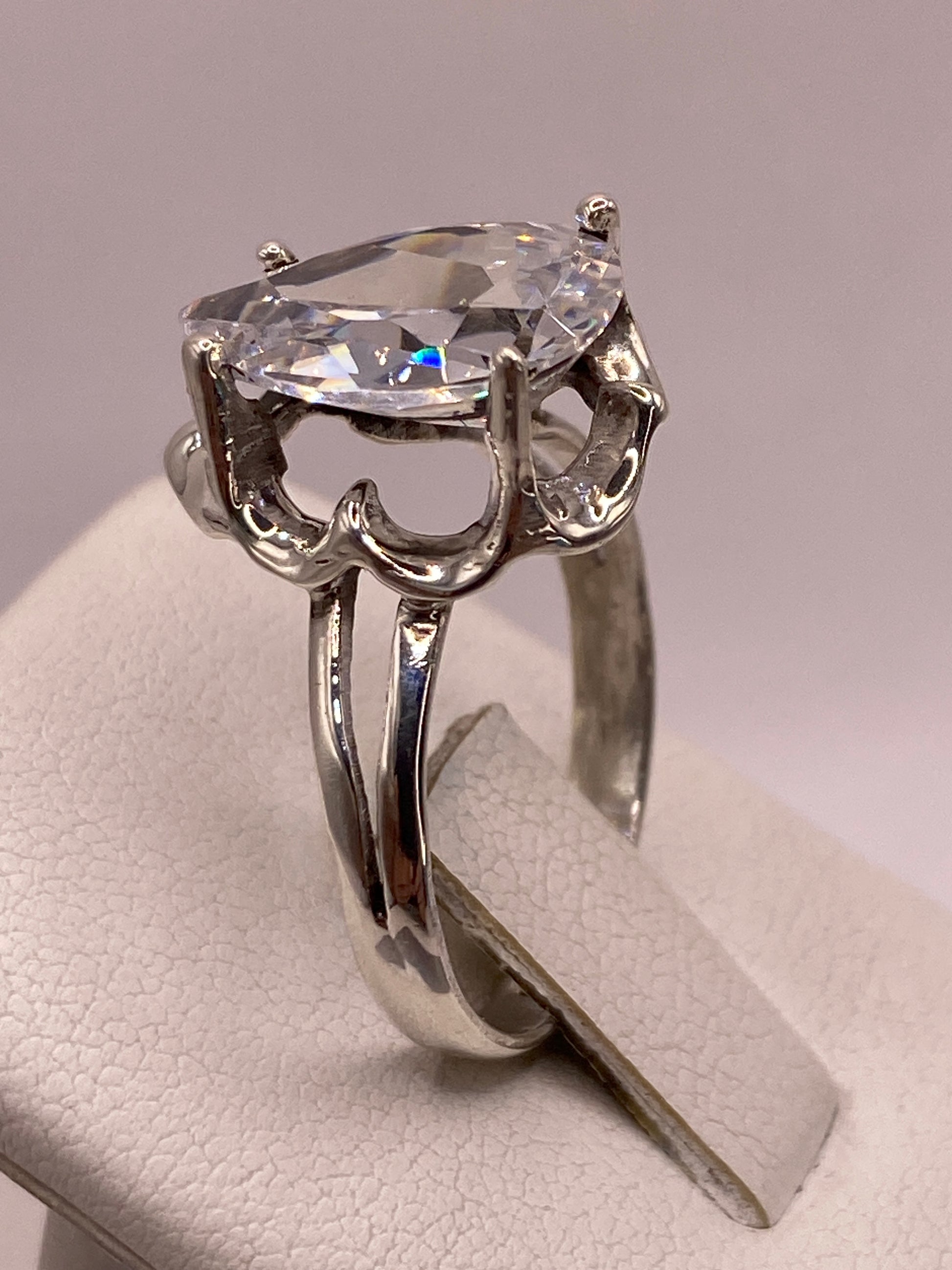Anillo solitario gota en mano de mujer, brillo transparente de la circonia
