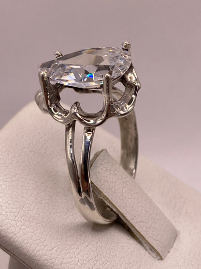 Anillo solitario gota en mano de mujer, brillo transparente de la circonia