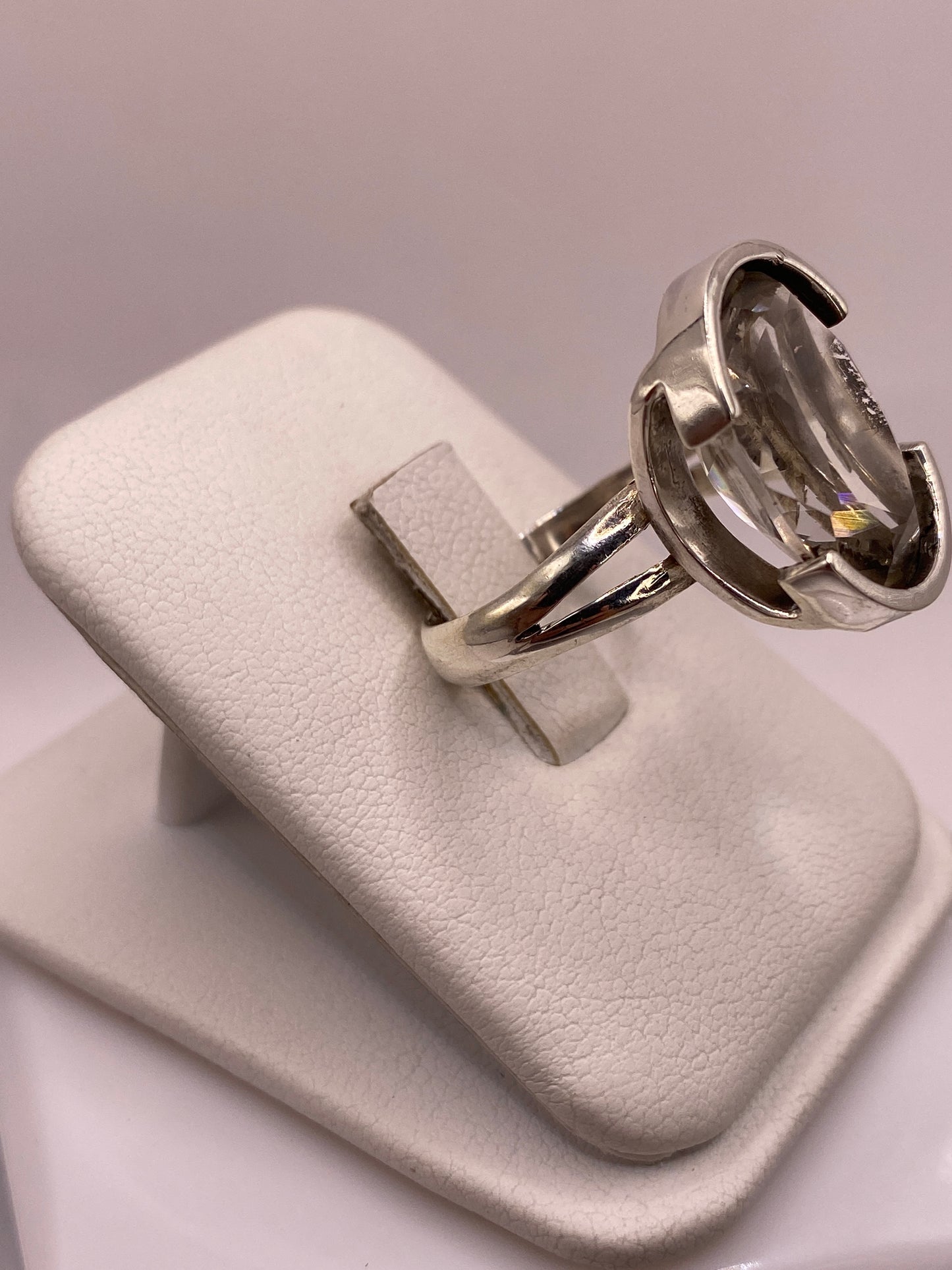 Detalle lateral del anillo mostrando el engaste a mano y la banda de plata pulida espejo