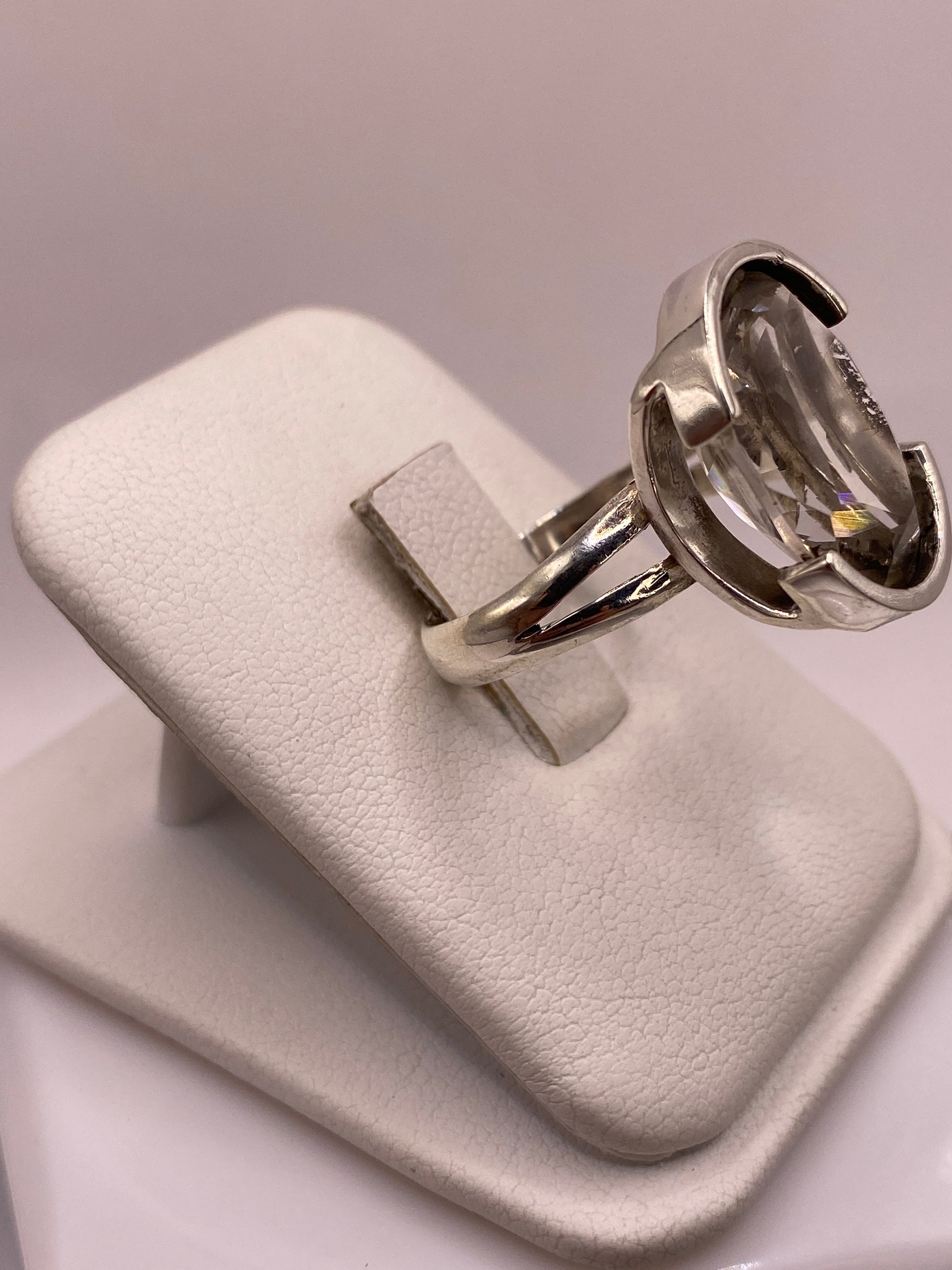 Detalle lateral del anillo mostrando el engaste a mano y la banda de plata pulida espejo