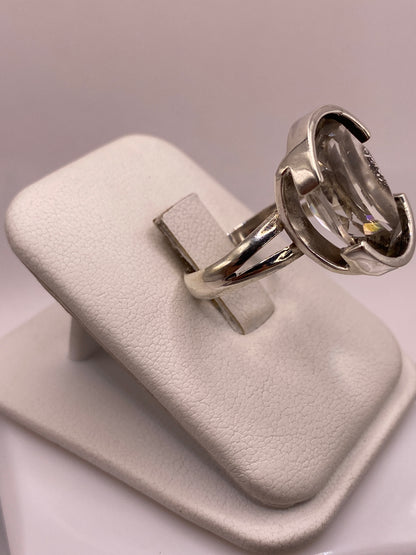 Detalle lateral del anillo mostrando el engaste a mano y la banda de plata pulida espejo