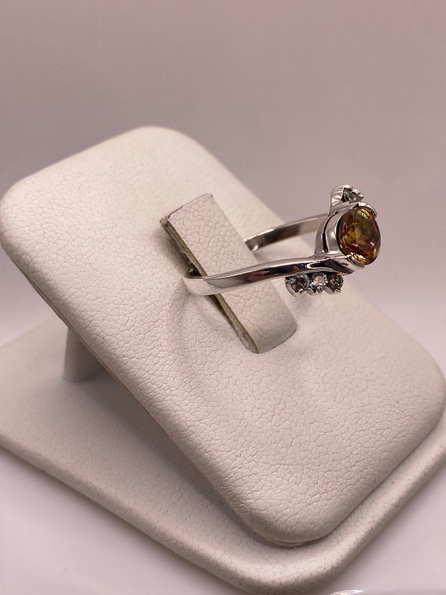 Anillo de plata .925 con circonia ámbar en la mano, mostrando brillo coctel