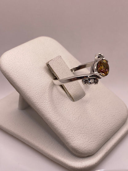 Anillo de plata .925 con circonia ámbar en la mano, mostrando brillo coctel