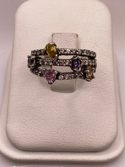 Anillo de plata vintage con circonias amarillas, púrpura y blancas en la mano de una mujer