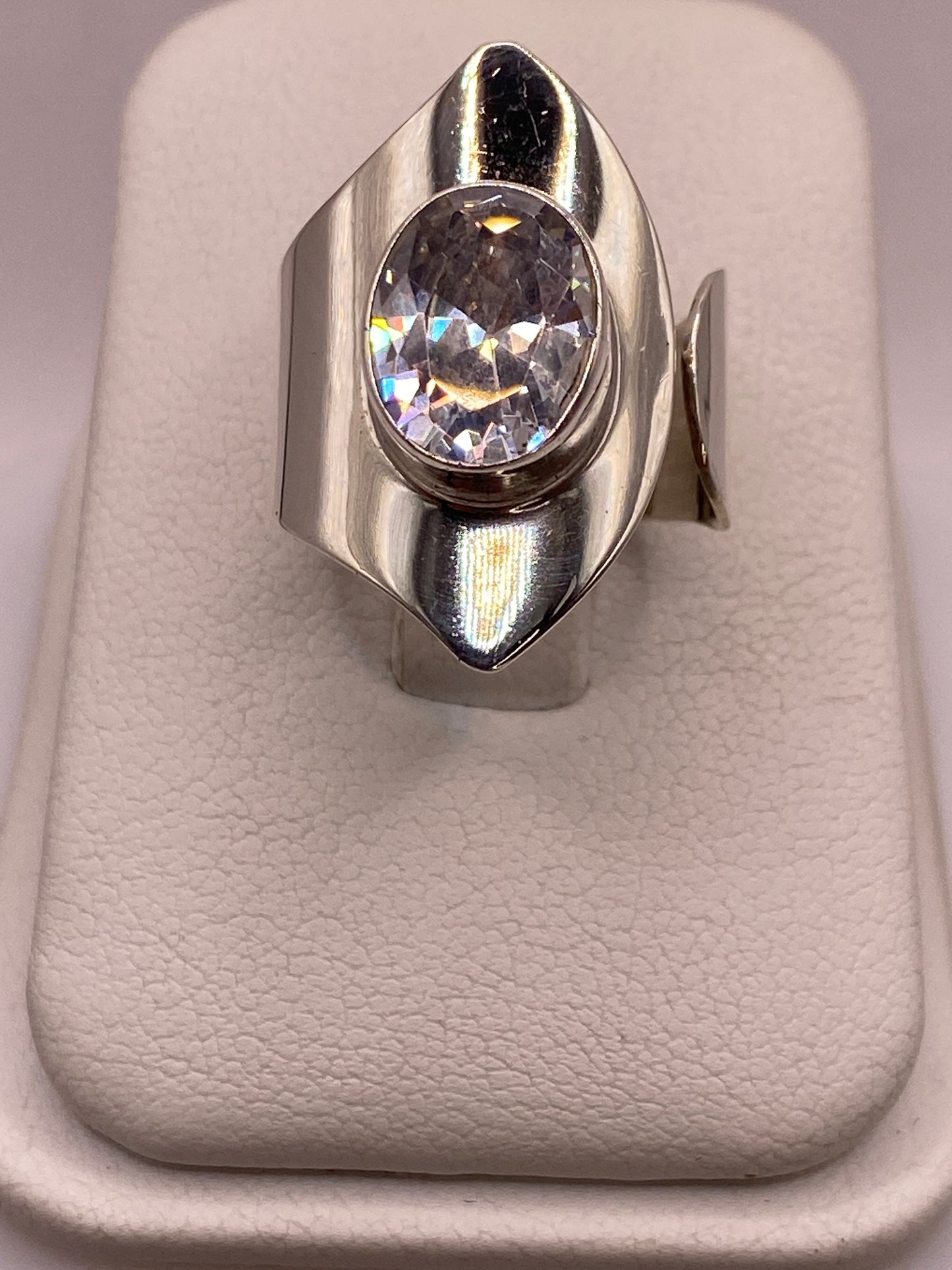 Anillo de plata ajustable con circonia blanca ovalada facetada en la mano de una mujer