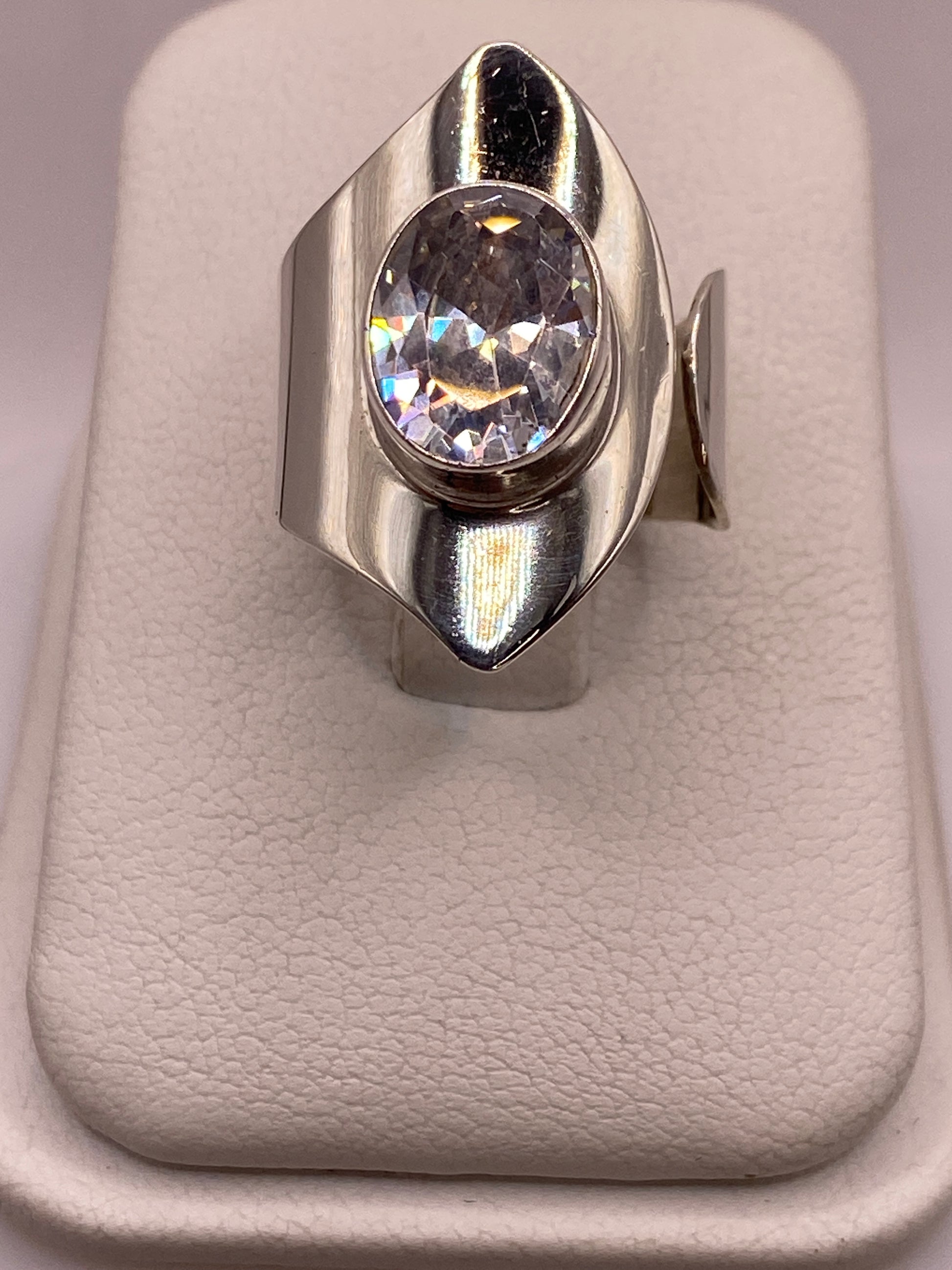 Anillo de plata ajustable con circonia blanca ovalada facetada en la mano de una mujer