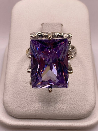 Anillo solitario de plata .925 con circonia púrpura rectangular, montado con filigrana ornamental en la banda