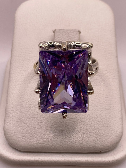 Anillo solitario de plata .925 con circonia púrpura rectangular, montado con filigrana ornamental en la banda