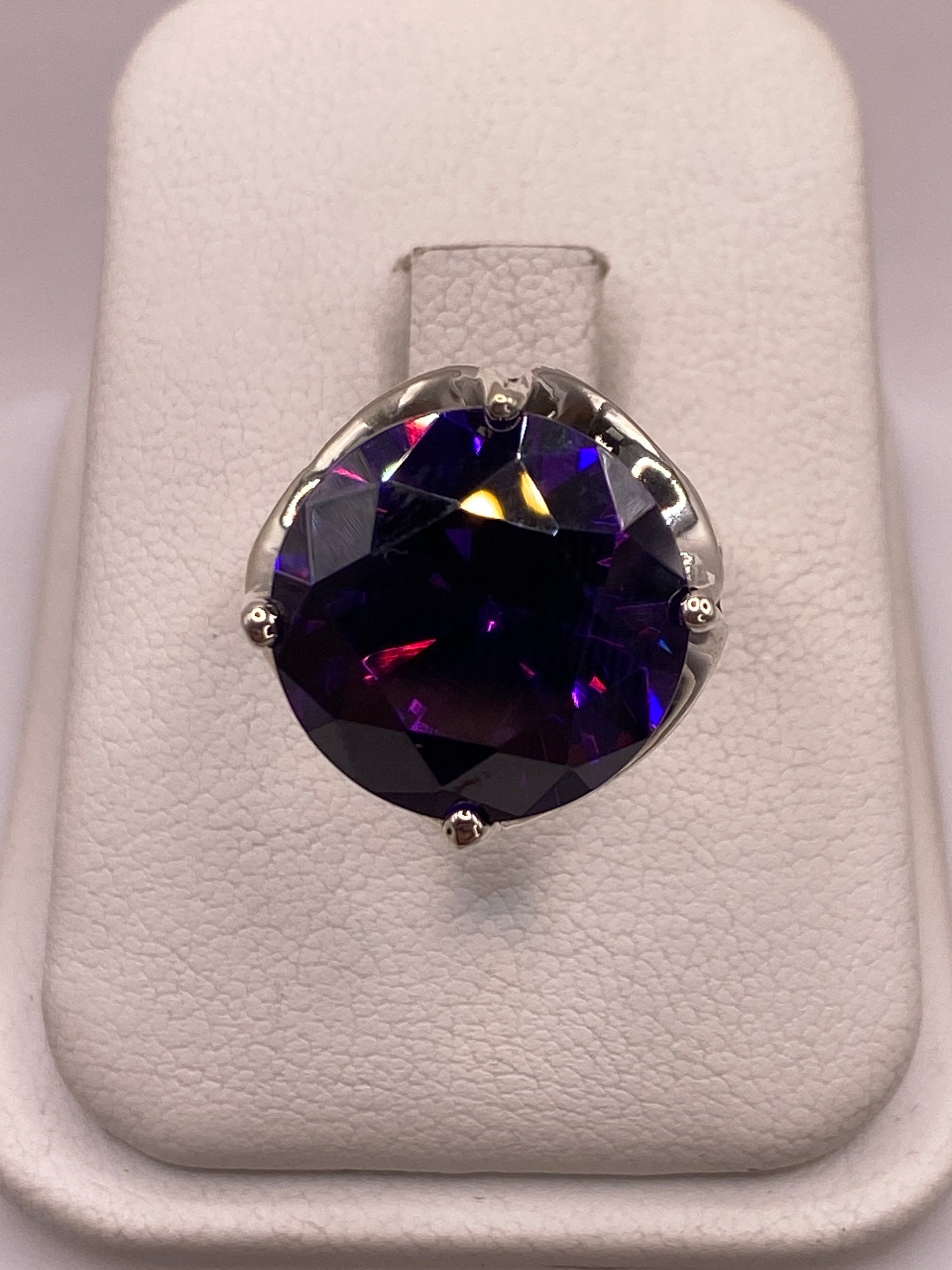 Anillo solitario de plata .925 con circonia azul profundo en montura de cuatro puntas, sobre estuche blanco