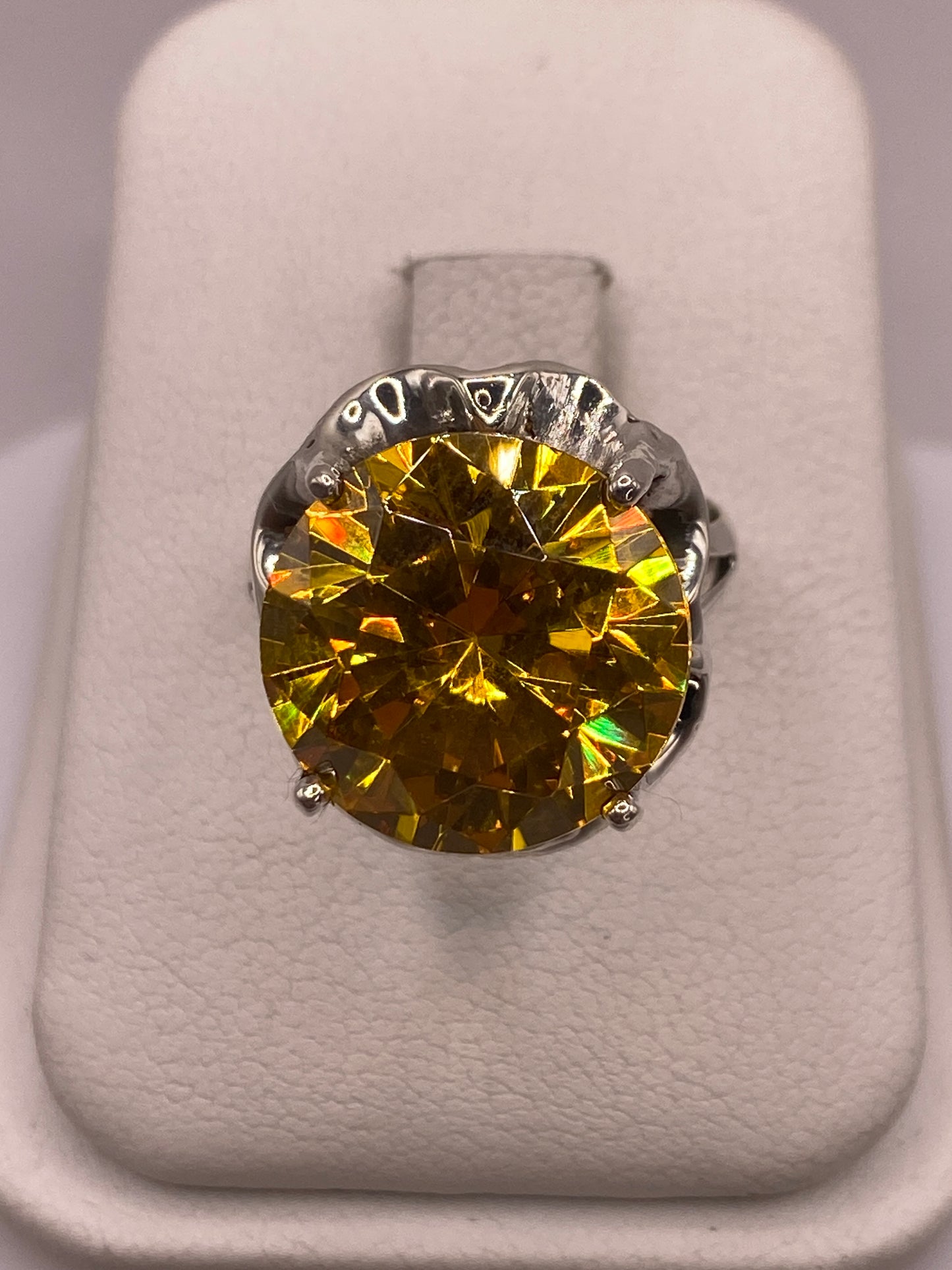 Anillo solitario de plata con circonia amarilla facetada en montura tallada, vista frontal