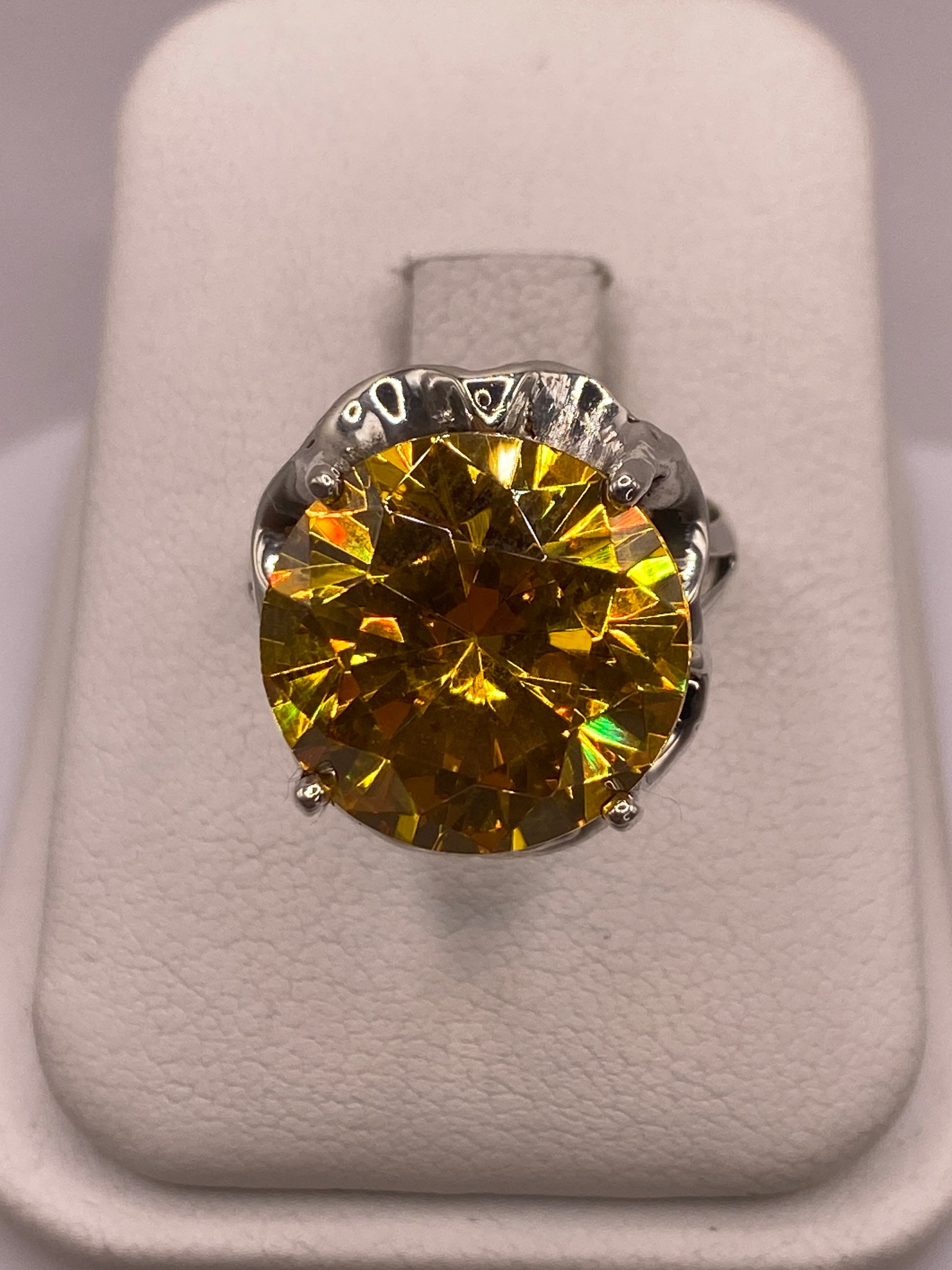 Anillo solitario de plata con circonia amarilla facetada en montura tallada, vista frontal