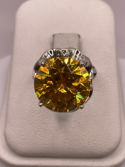 Anillo solitario de plata con circonia amarilla facetada en montura tallada, vista frontal