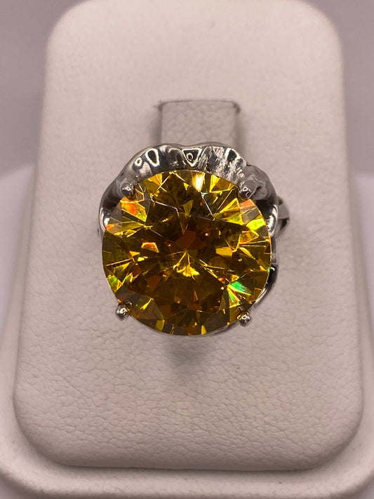 Anillo solitario de plata con circonia amarilla facetada en montura tallada, vista frontal