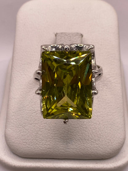 Anillo de plata con circonia amarilla rectangular en mano femenina, mostrando brillo tipo diamante