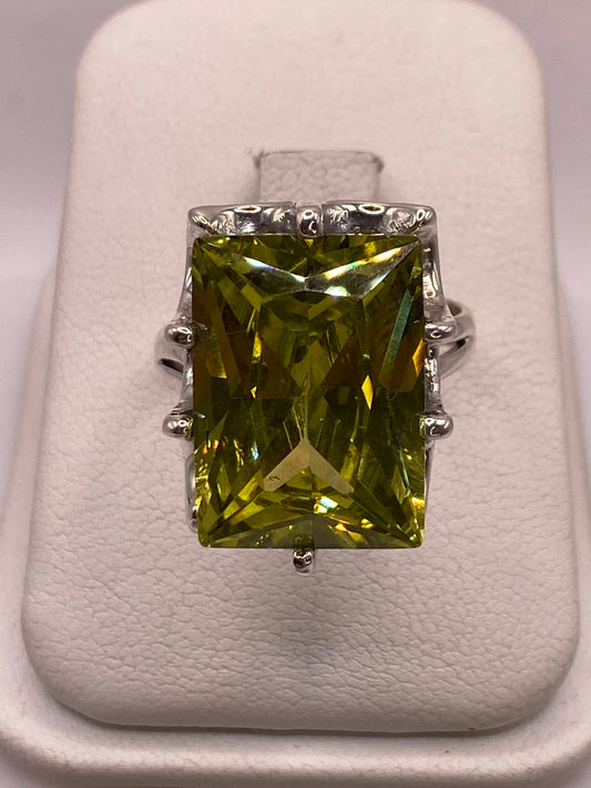 Anillo de plata con circonia amarilla rectangular en mano femenina, mostrando brillo tipo diamante