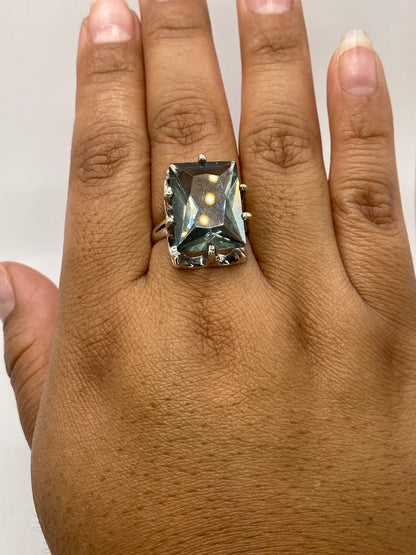Anillo solitario en dedo de mujer: la circonia gris ahumado captura luz con fuego blanco diamantado