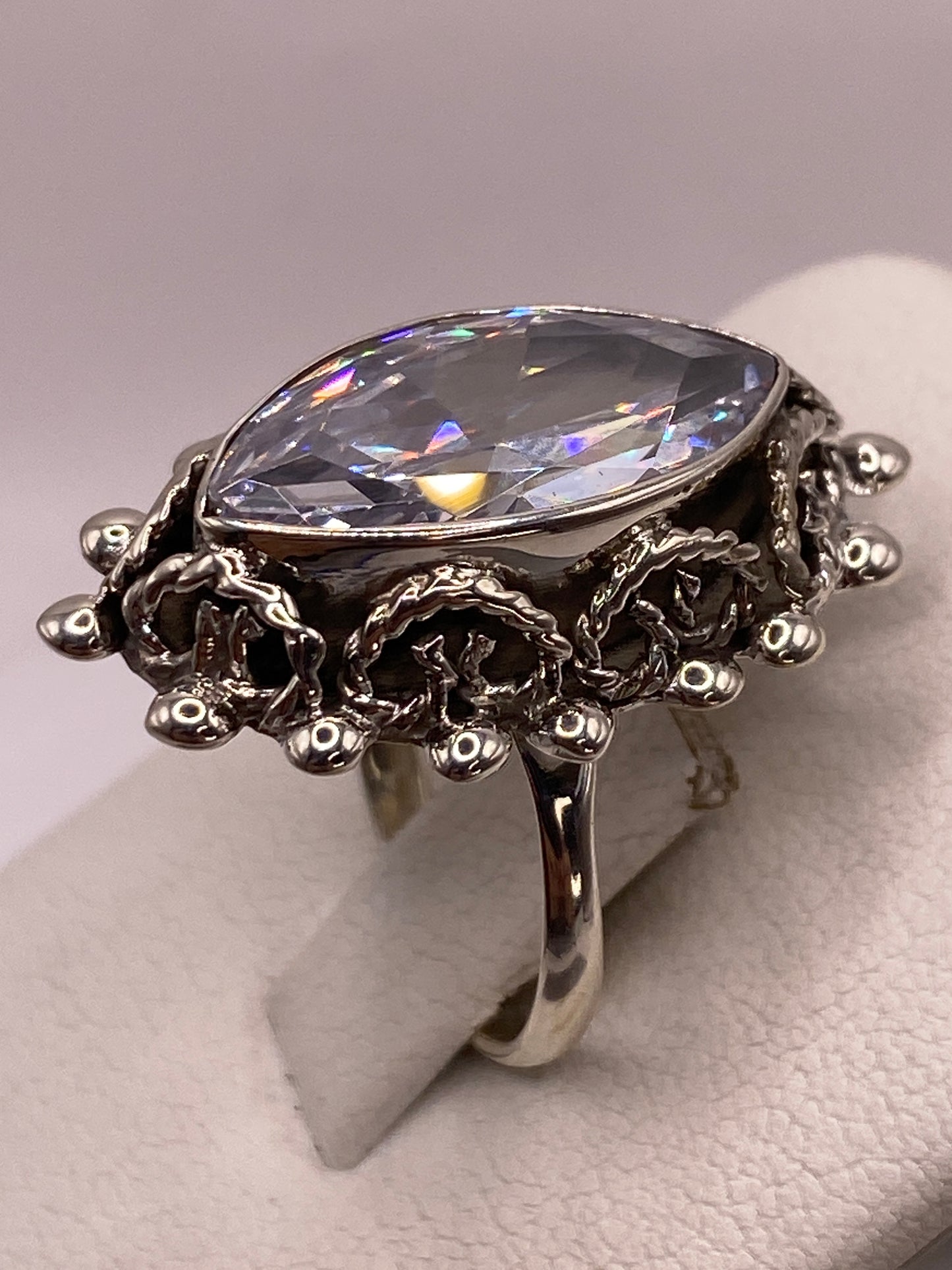 Anillo de plata en la mano, detalles del marco ornamental en relieve