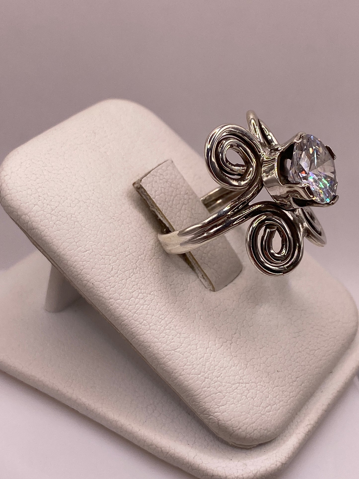 Anillo solitario con espirales artesanales y circonia brillante visto de frente