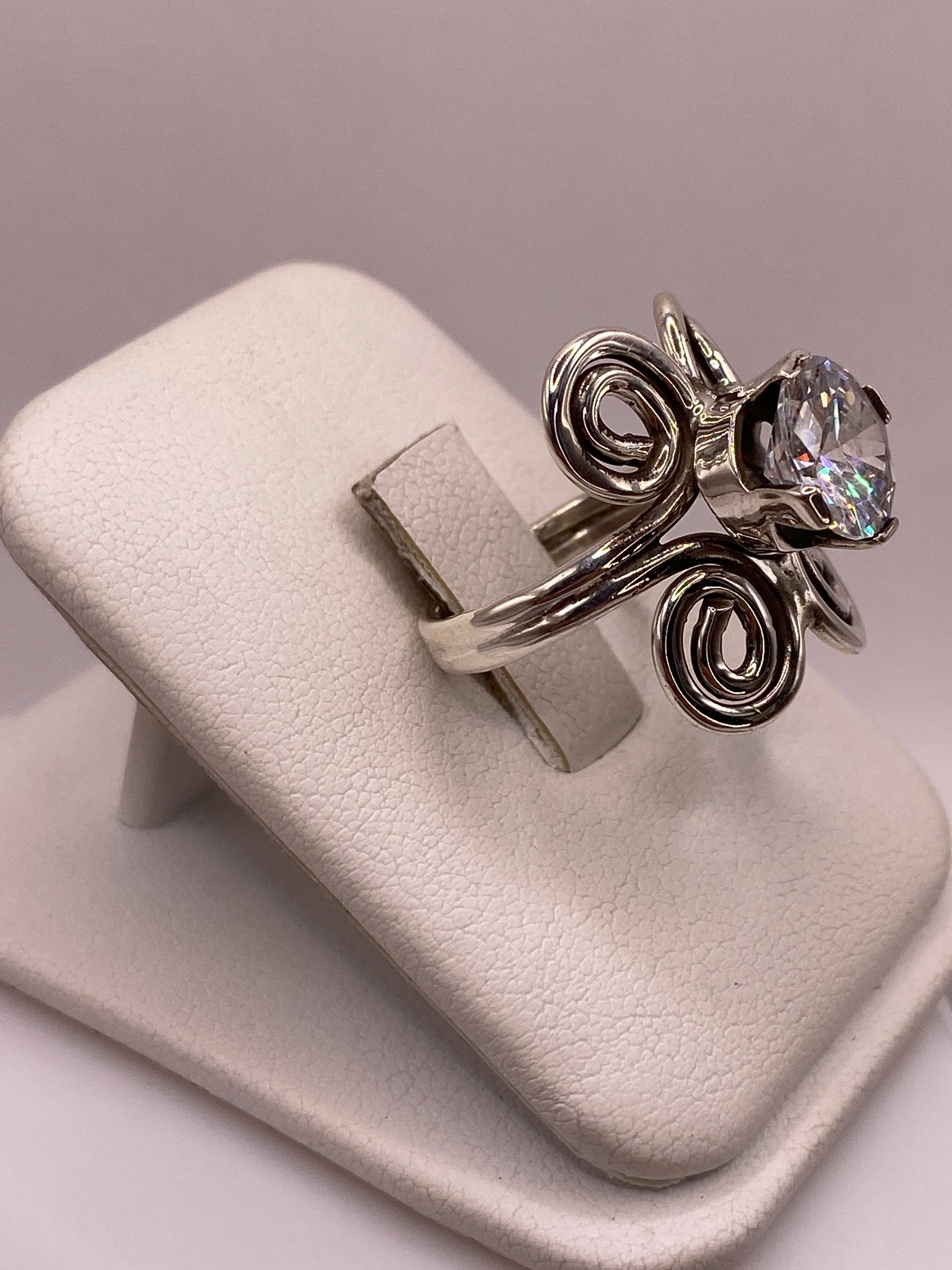 Anillo solitario con espirales artesanales y circonia brillante visto de frente