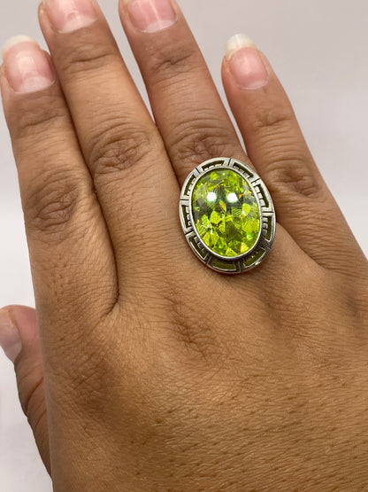 Anillo de plata solitario en dedo de mujer, luz verde limón intensa