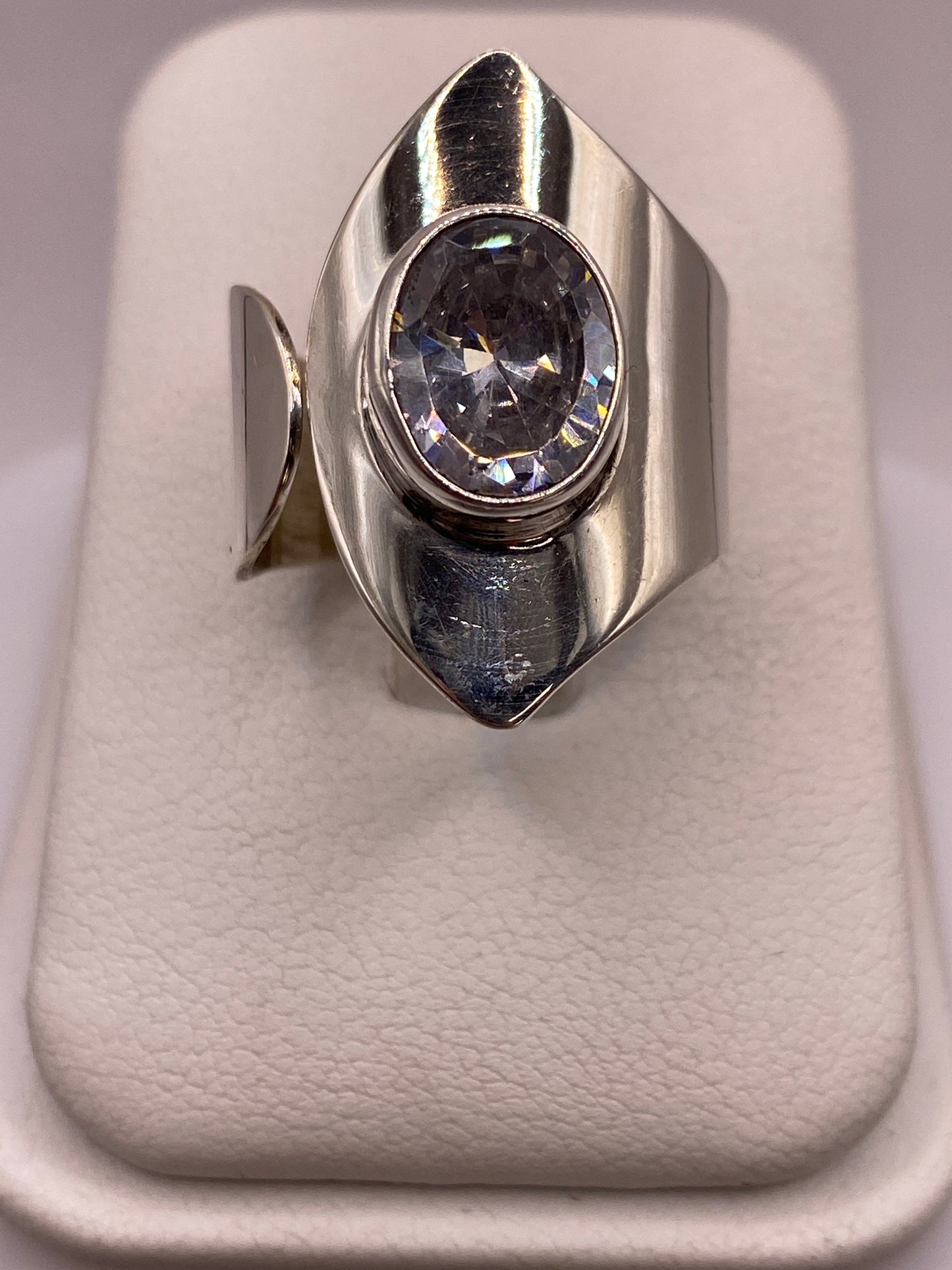 Anillo solitario de plata con circonia cristalina en la mano de una mujer