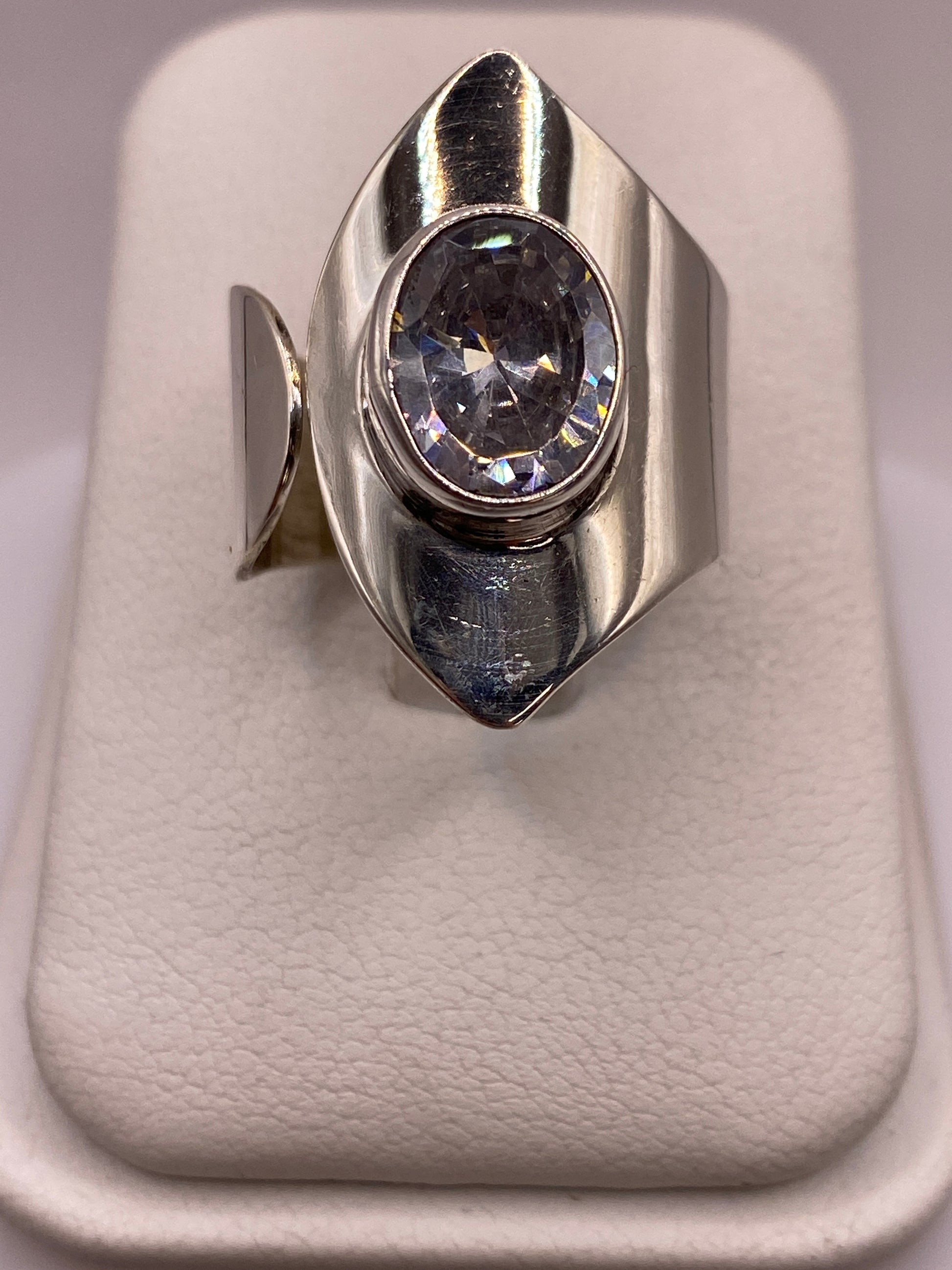 Anillo solitario de plata con circonia cristalina en la mano de una mujer