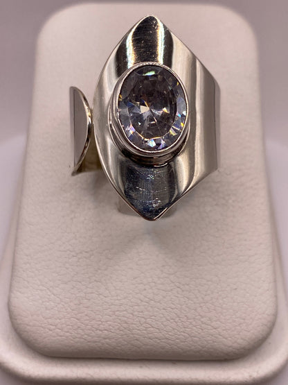 Anillo solitario de plata con circonia cristalina en la mano de una mujer