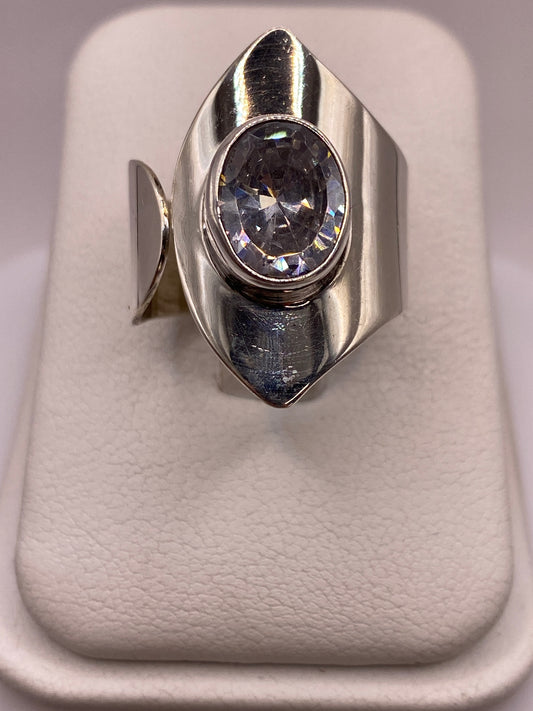 Anillo solitario de plata con circonia cristalina en la mano de una mujer
