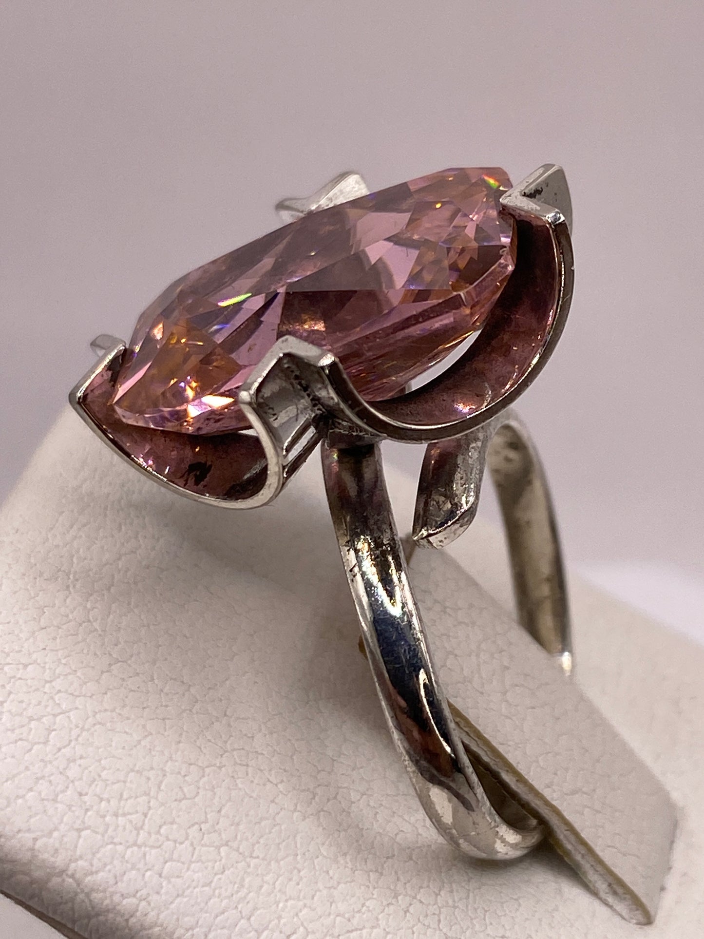 Anillo de circonia rosa en la mano con luz natural mostrando el brillo
