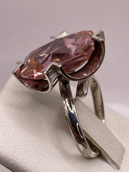 Anillo de circonia rosa en la mano con luz natural mostrando el brillo