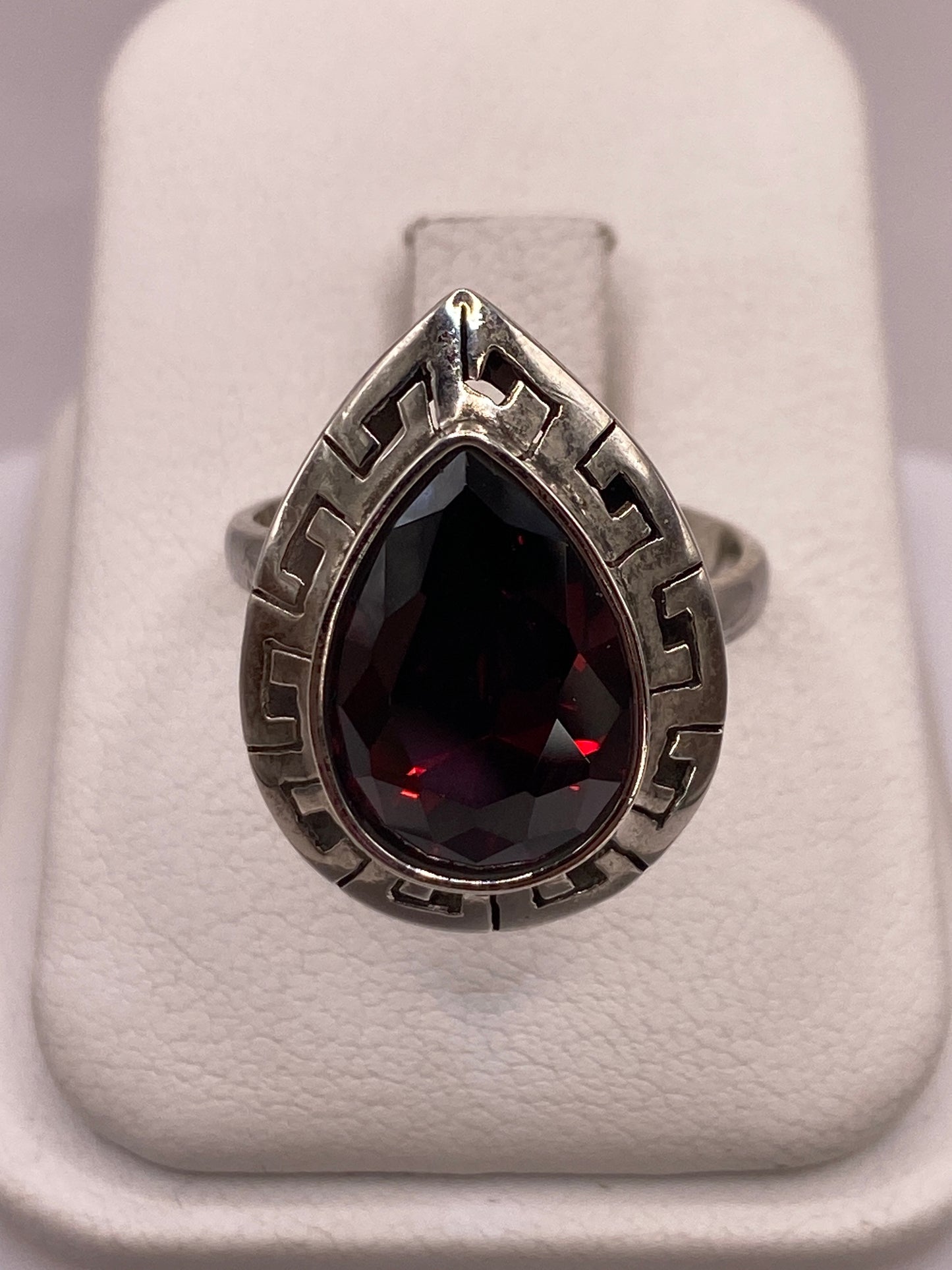 Anillo solitario de plata .925 con circonia roja facetada en la mano de una mujer
