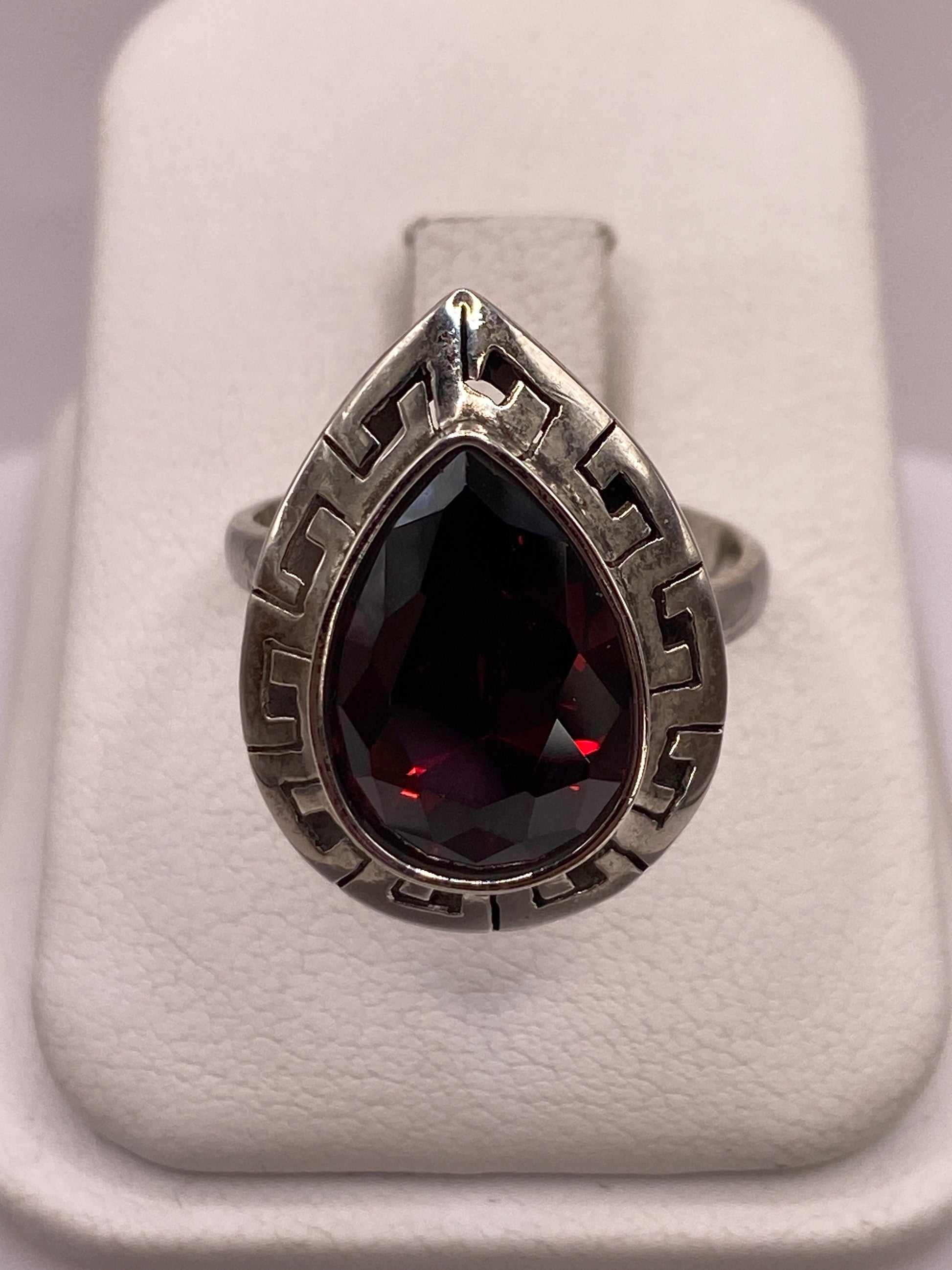 Anillo solitario de plata .925 con circonia roja facetada en la mano de una mujer