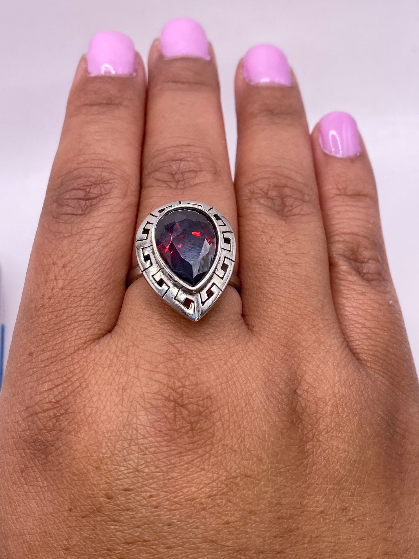 Anillo ajustable de plata con sello .925 y circonia roja en detalle