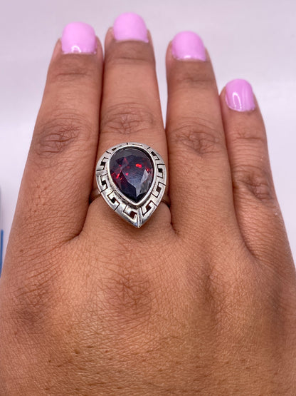 Anillo ajustable de plata con sello .925 y circonia roja en detalle