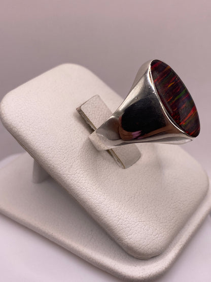 Vista frontal del anillo ópalo fuego con juego de colores verde, azul y rojo en la gema natural