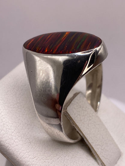Detalle lateral del engaste de bisel en plata pulida del anillo ópalo de fuego Taxco