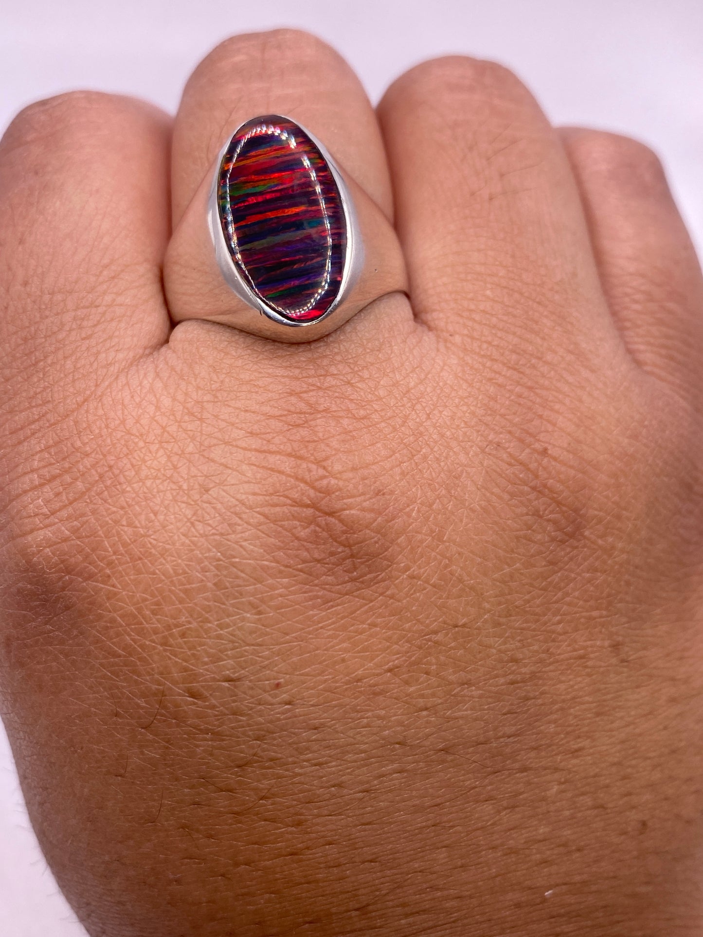 Anillo solitario ópalo fuego sobre estuche blanco mostrando sello .925 MEXICO en la banda interior
