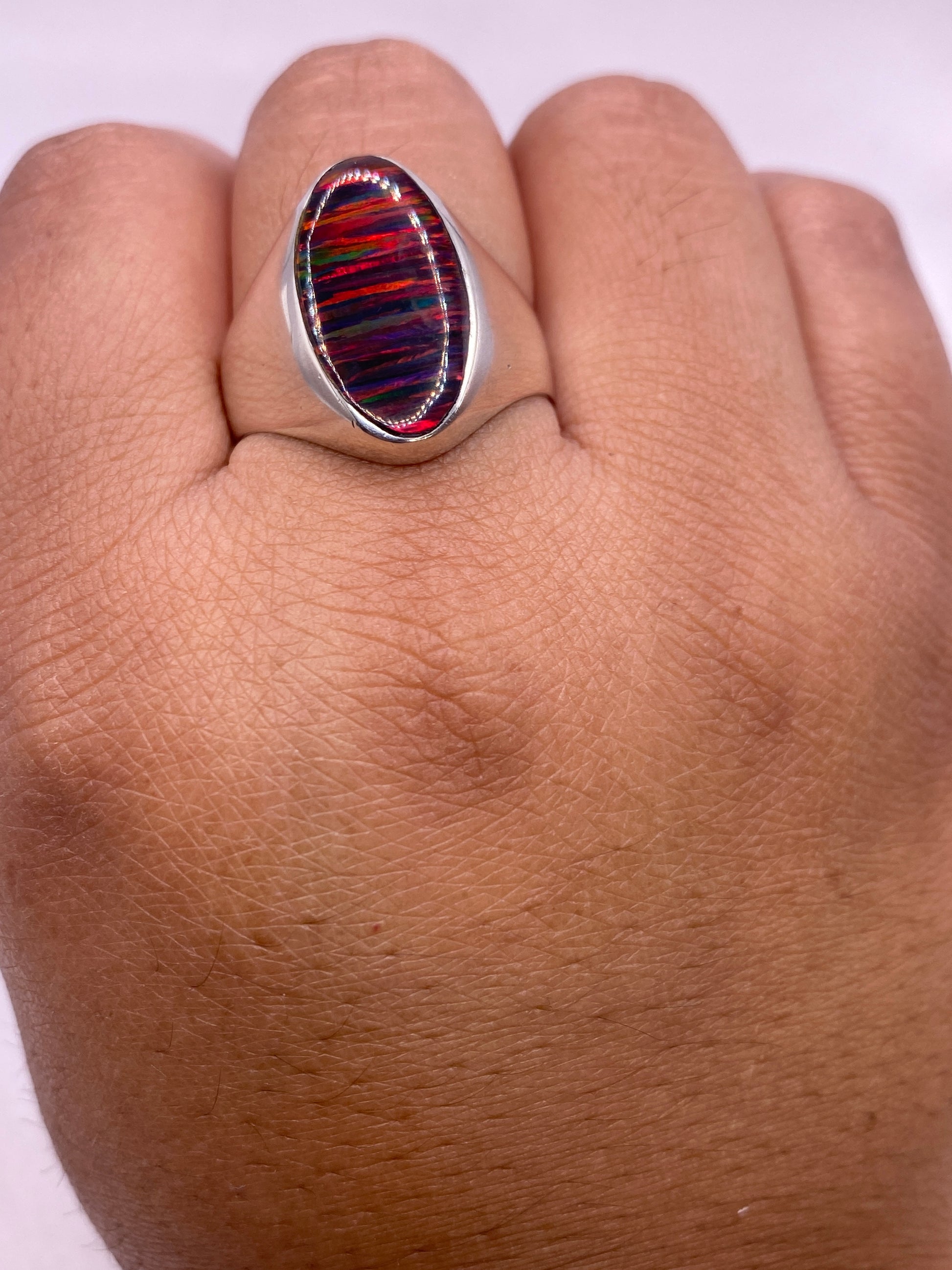 Anillo solitario ópalo fuego sobre estuche blanco mostrando sello .925 MEXICO en la banda interior