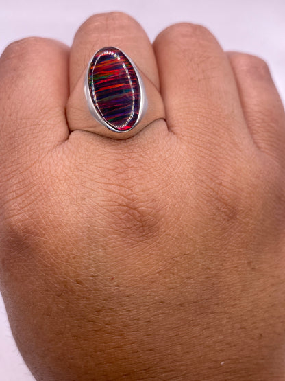 Anillo solitario ópalo fuego sobre estuche blanco mostrando sello .925 MEXICO en la banda interior