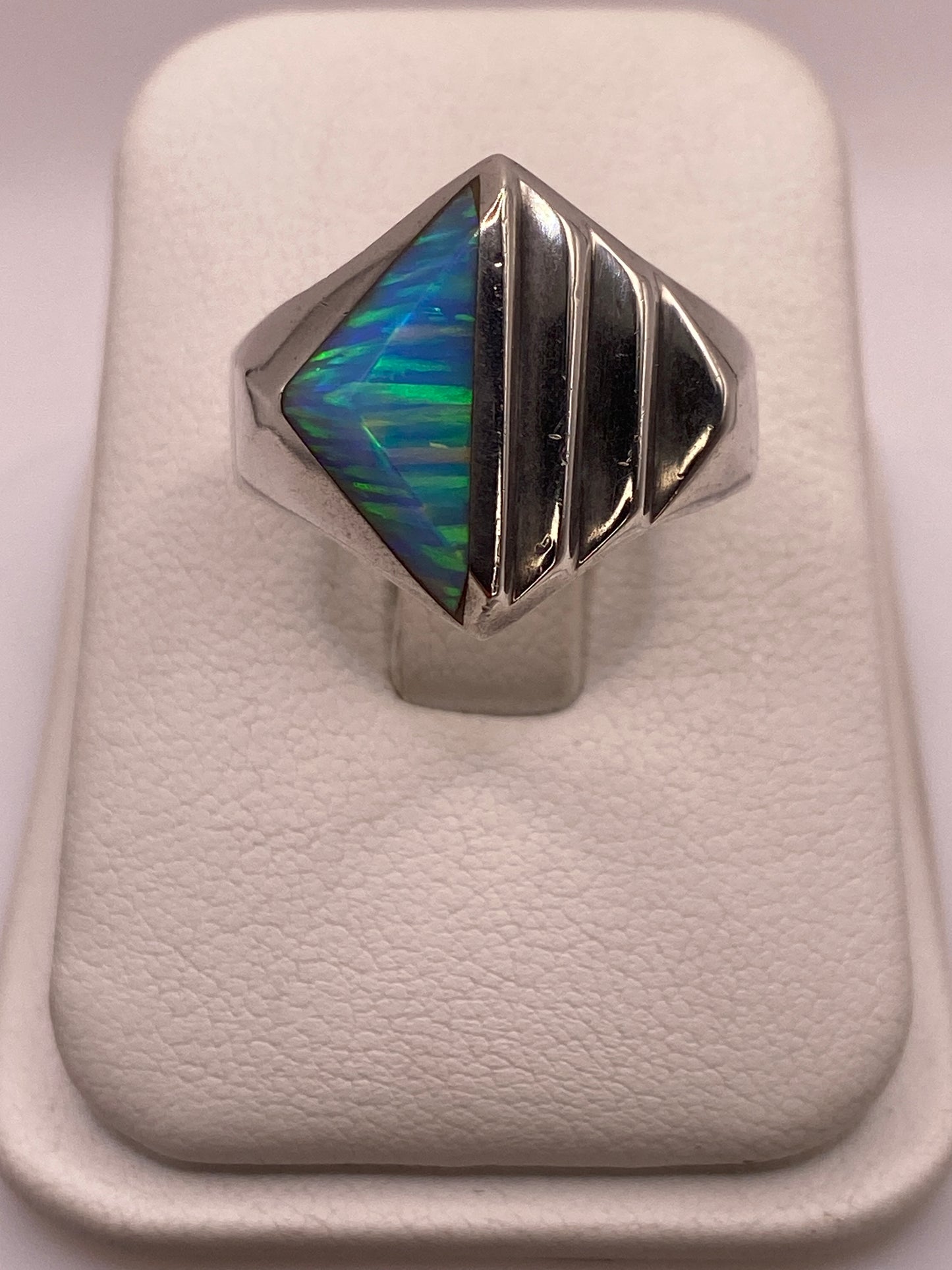 Anillo de plata .950 con ópalo de fuego azul cielo mostrando vetas de color en la mano